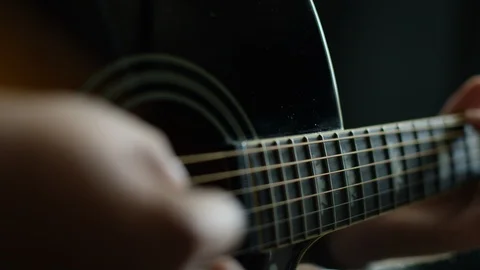 Mid section of man strums his guitar Stock Footage 108934319