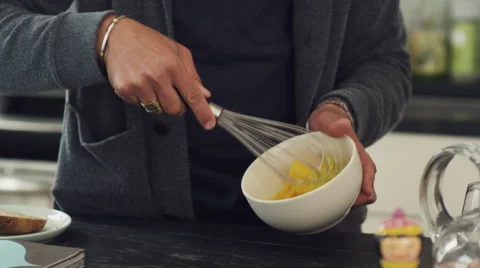 Mid-section of man whisking egg in bowl in kitchen Stock Footage 63860633
