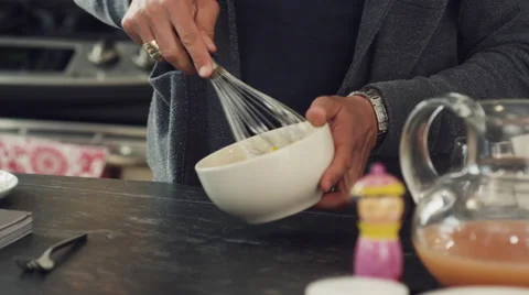 Mid-section of man whisking egg in bowl in kitchen Stock Footage 63860634