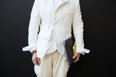 Mid section of a man in a white jacket and cream trousers Stock Photos