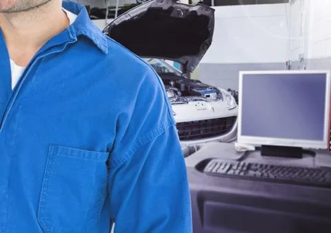 Mid section of mechanic with computer in background Fotos de archivo