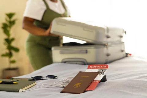 Mid section of plus size african american woman packing suitcase in bright Stock Photos