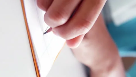 Mid-section of school kid doing homework in classroom at school Stock Footage 301498977