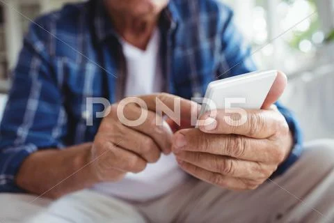 Mid-Section Of Senior Man Using Mobile Phone