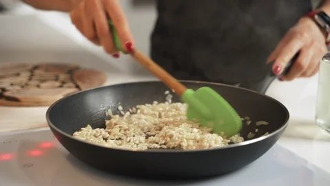 Mid-section shot of hands of unrecognizable female cooking risotto Stock-Footage 99464271