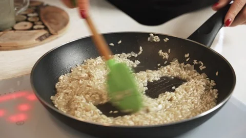 Mid-section shot of hands of unrecognizable female cooking risotto Stock Footage 99465601