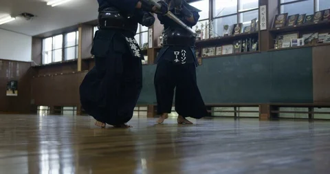 Mid section of two man practising kendo with wooden katana swords in slow motion Stock Footage 124687632