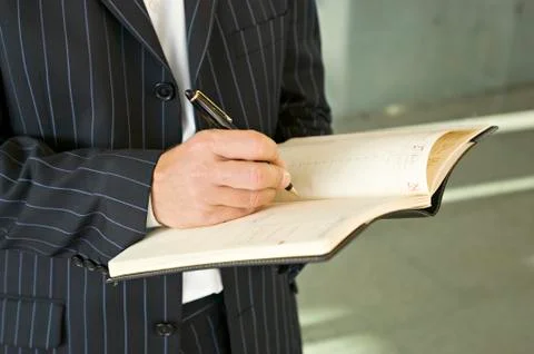 Mid section view of a businessman writing in a diary Stock Photos