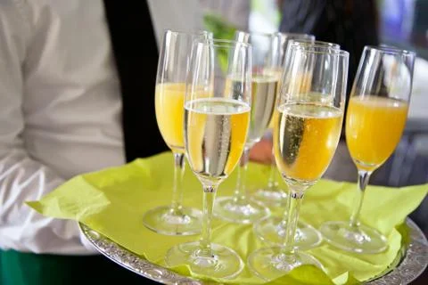 Mid section view of waiter serving champagne and orange juice on christmas or Stock Photos