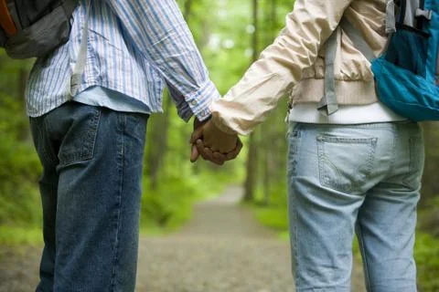 Mid section view of a young couple holding hands and standing Stock Photos