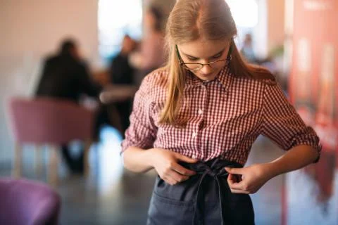 Mid section of waitress wearing apron at cafe Foto stock