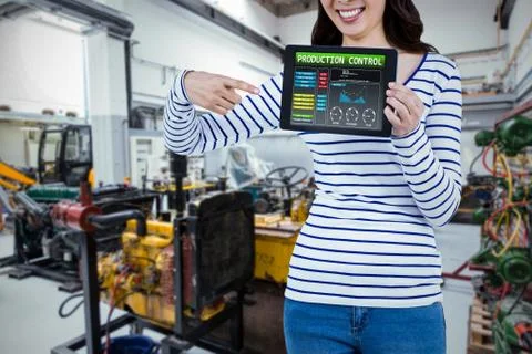 Mid section of woman pointing at tablet computer against mechanic workshop Foto stock