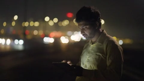 A mid shot of an Asian man using digital tablet against the city traffic Stock Footage 330886043