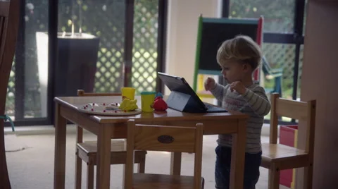 Mid shot of a child playing with an iPad at home in his living room Stock Footage 65301367