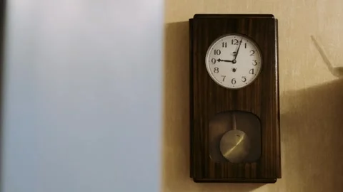 Mid-shot cuckoo clock with pendulum hanging on the wall Video stock 296096364