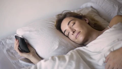 Mid-shot elevated view of adult woman checking messages on smartphone while Stock Footage 277967231