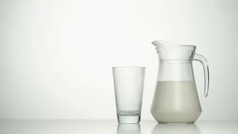 Mid shot of female hand taking jug of milk and pouring into empty glass Stock Footage 75953645