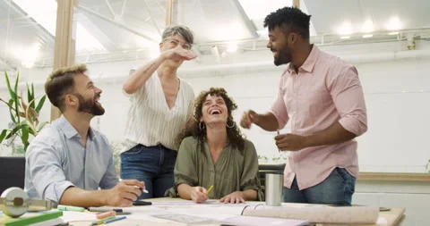 Mid-shot front view of cheerful group of coworkers reviewing details of Stock Footage 277947731