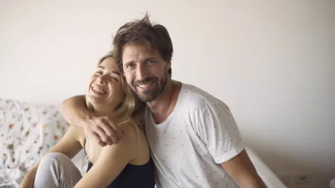 Mid-shot front view of cheerful heterosexual couple looking at camera while Stock Footage 277968252