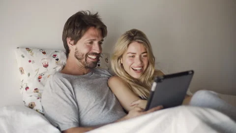 Mid-shot front view of cheerful young couple having a good time in their bed Stock Footage 277968524