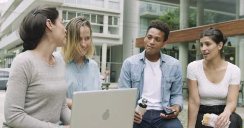 Mid-shot front view of diverse group of coworkers exchanging ideas while taking Stock Footage 277965891