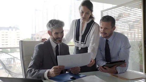 Mid-shot front view of female paralegal showing document draft to two male Stockbeeldmateriaal 277972223