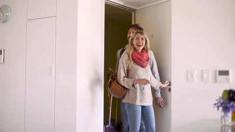 Mid-shot front view of happy young couple entering their temporary rental Stock Footage 277969766