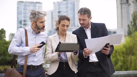Mid-shot front view of three coworkers sharing information while taking a coffee Stockbeeldmateriaal 277974839