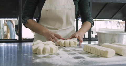 Mid-shot front view of unrecognizable person's hands making bread inside bakery Stock Footage 277958586