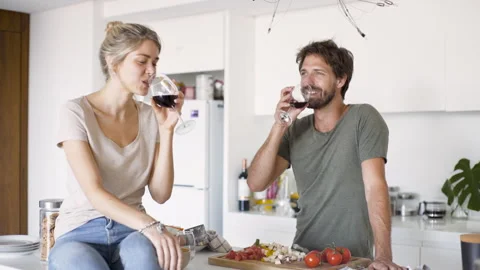 Mid-shot front view of young couple enjoying a glass of wine while hanging out Stock Footage 277968988