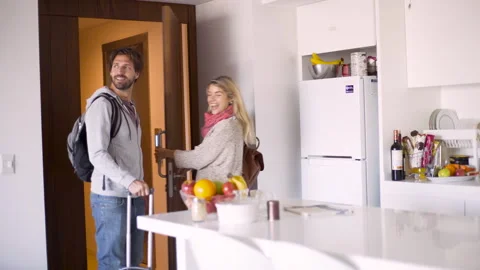 Mid-shot front view of young couple cheerfully looking around their recently Stock Footage 277969822