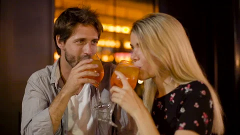 Mid-shot front view of young couple making a toast while enjoying a night out in Stock Footage 277970624