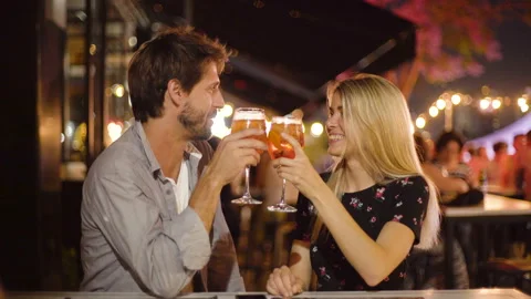 Mid-shot front view of young newlyweds having drinks while enjoying a night out Video stock 277970833