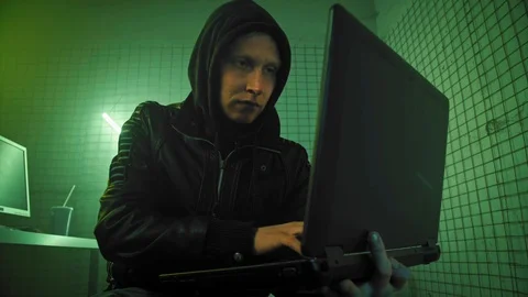 Mid Shot of a Hacker in Holding Laptop and Hacking Data Server. Shot on 4k. Stock Footage 106352876