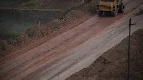 Mid shot of heavy mining trucks carring cargo in opencast mining quarry in sunny Stock Footage 75376921