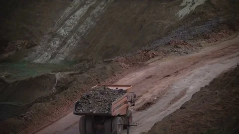 Mid shot of heavy mining trucks carring cargo in opencast mining quarry in sunny Stock Footage 75378172