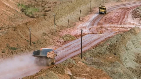 Mid shot of heavy mining trucks carring cargo in opencast mining quarry in sunny Video stock 75460922