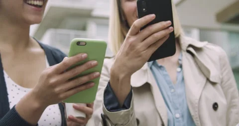 Mid-shot low angle view of two young women having a good time while looking at Stock Footage 277966003
