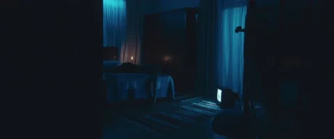 Mid-shot for man in bed room with a flying curtain, candle and old TV Stock Footage 213104031