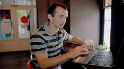 Mid shot Man working on computer and drink coffee in cafe Stock Footage 65716521