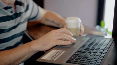 Mid shot Man working on computer and drink coffee in cafe Stock Footage 65716788