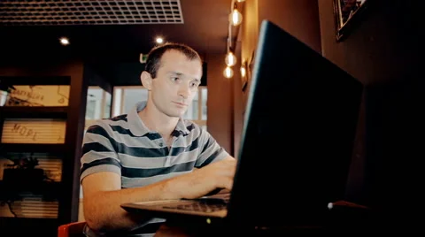 Mid shot Man working on computer and drink coffee in cafe Stock Footage 65717053