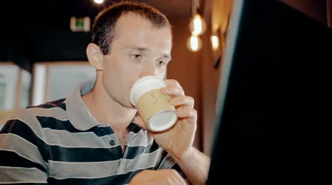 Mid shot Man working on computer and drink coffee in cafe Stock Footage 65717186