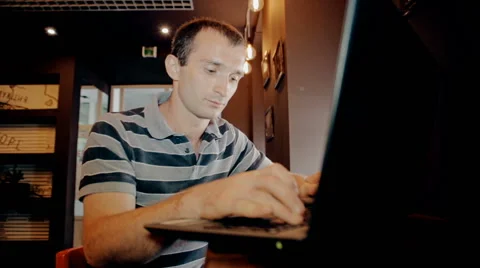 Mid shot Man working on computer and drink coffee in cafe Stock Footage 65717191