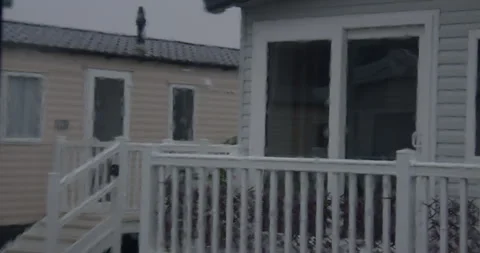 Mid Shot of rain on a static caravan window with static caravans Porch in Stock Footage 346814345