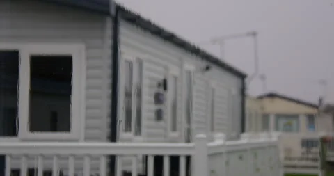 Mid Shot of rain on a static caravan window with static caravans in background Stock Footage 346814512