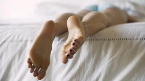 Mid-shot rear view of unrecognizable person's feet wiggling their toes while Vídeo Stock 277967573