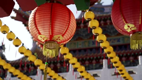 Mid shot of Red Lantern in front of many yellow laterns at chinese temple Stock Footage 229777889