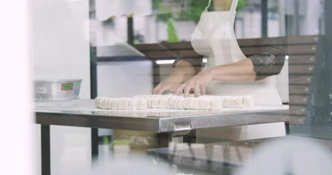 Mid-shot side view of unidentified person making bread inside bakery kitchen Stock Footage 277958904