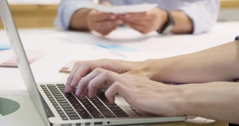 Mid-shot side view of unrecognizable person's hands typing on laptop computer's Stock Footage 277950018
